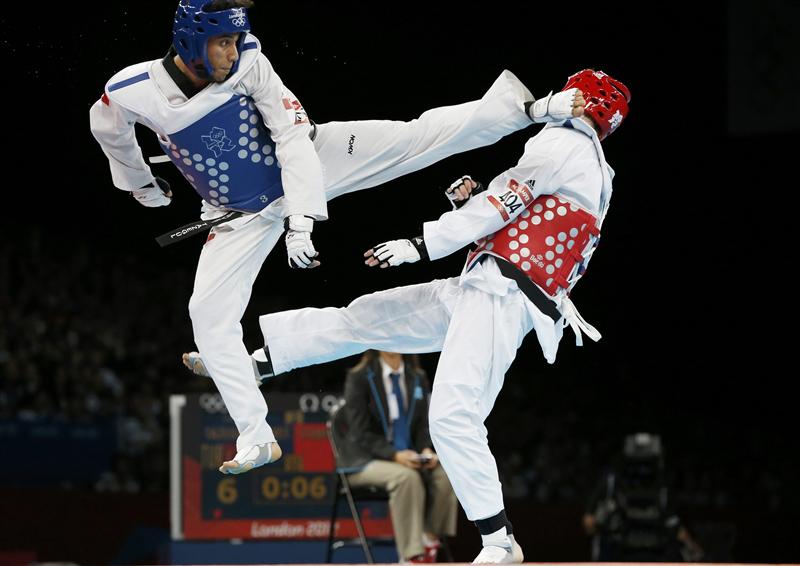 Turkey's Servet Tazegul (L) kicks Britain's Martin Stamper during their men's -68kg semifinal taekwondo match at the ExCel venue during the London Olympic Games, August 9, 2012. REUTERS/Kim Kyung-Hoon